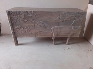 elegantly designed deer and forest carving on sideboard
